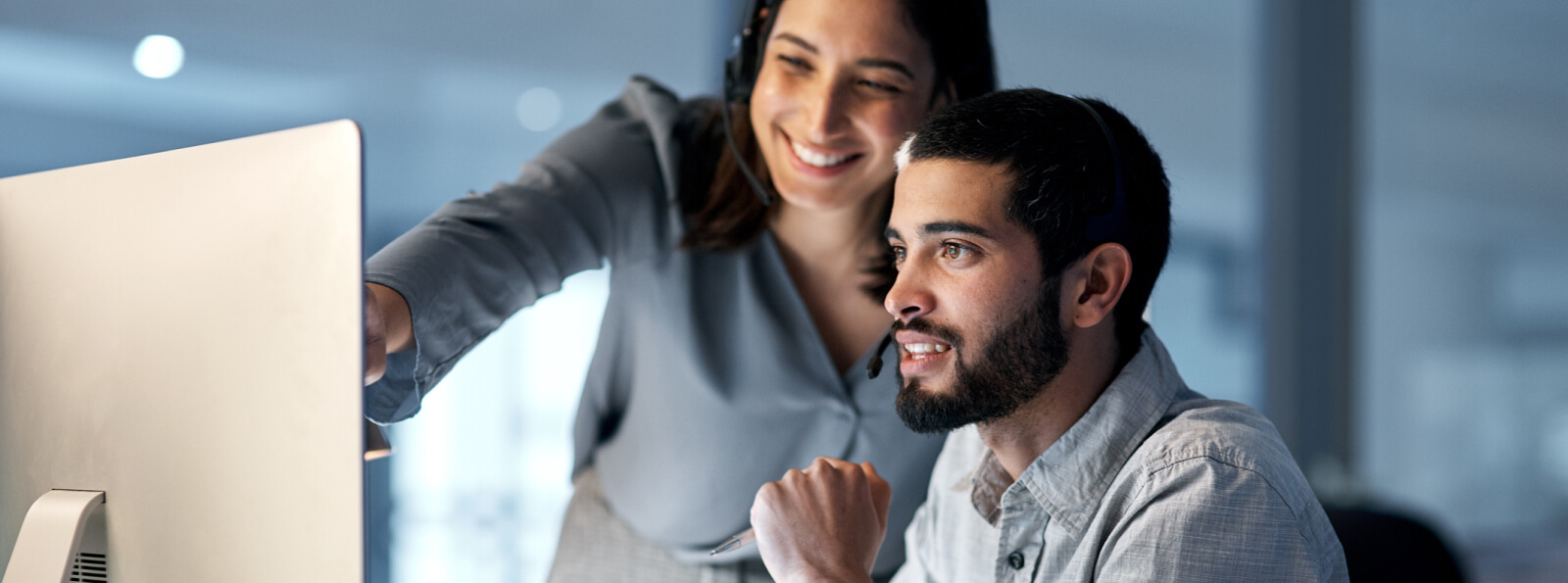 Two business people looking at a computer monitor together