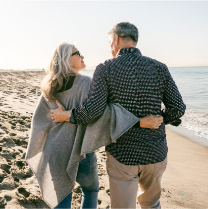 Older couple walking on a beach